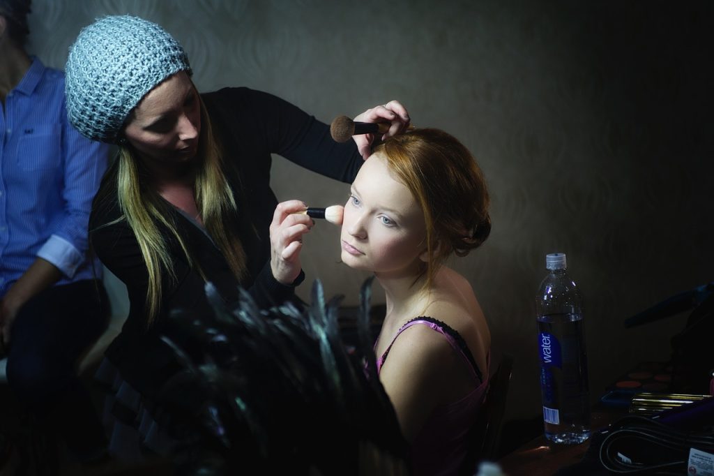 une maquilleuse qui maquille une femme