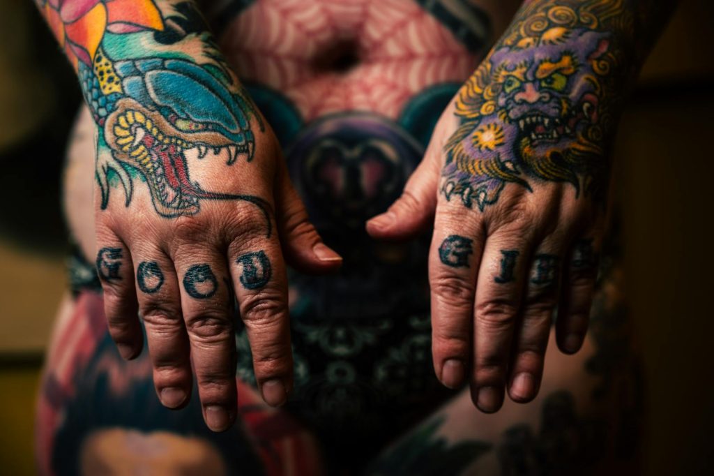 homme avec beaucoup de tatouages sur la main et les doigts