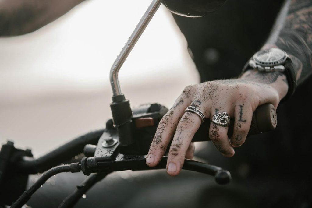 homme sur sa moto avec des tatouages sur les doigts